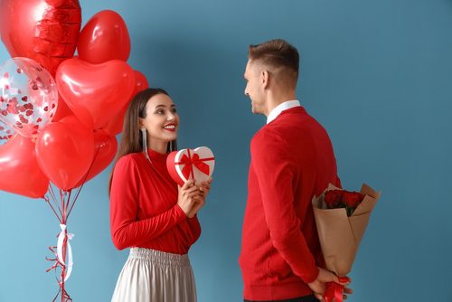 Young man and woman celebrating Valentine's Day with gifts.